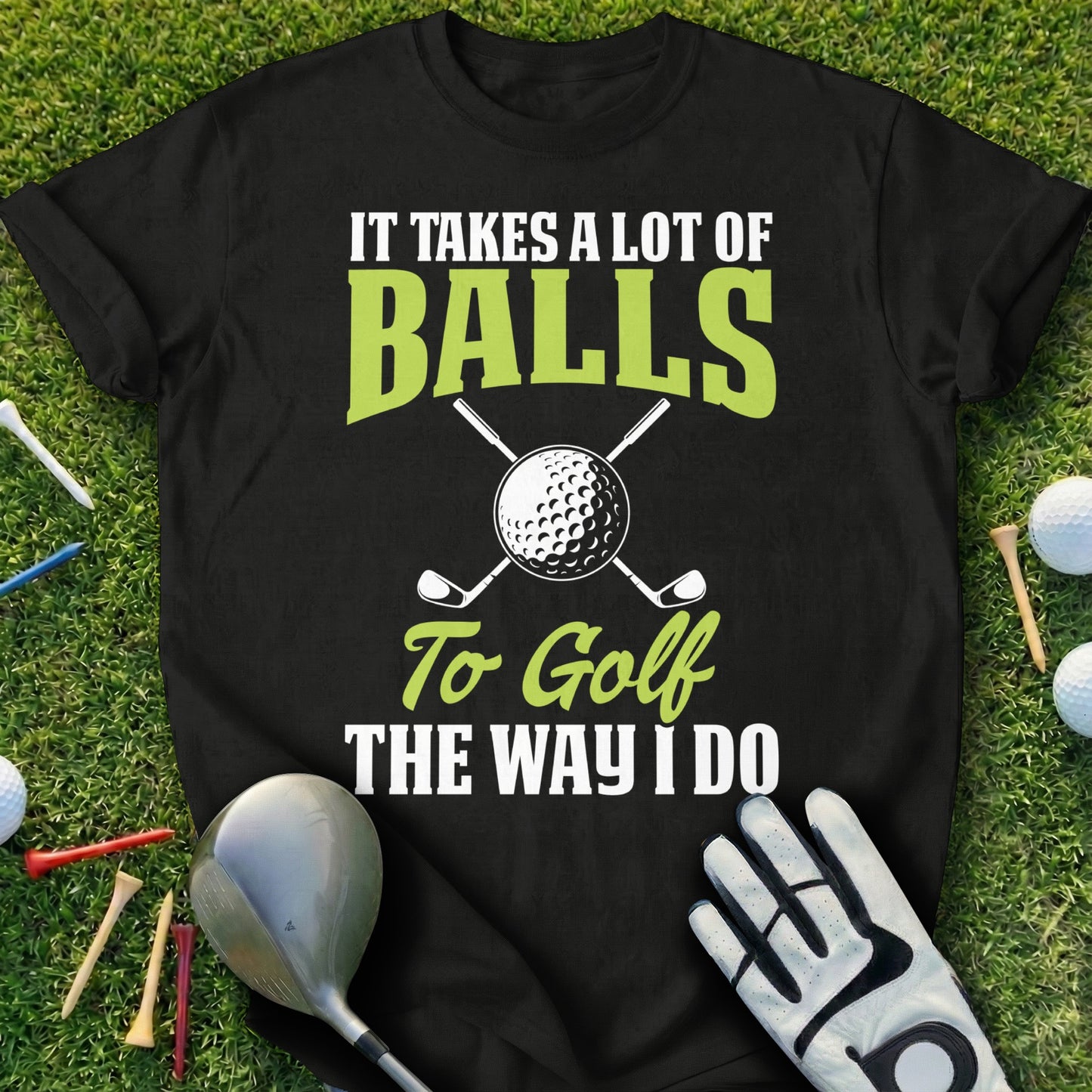 Black t-shirt with "It Takes a Lot of Balls to Golf the Way I Do" text and golf imagery.
