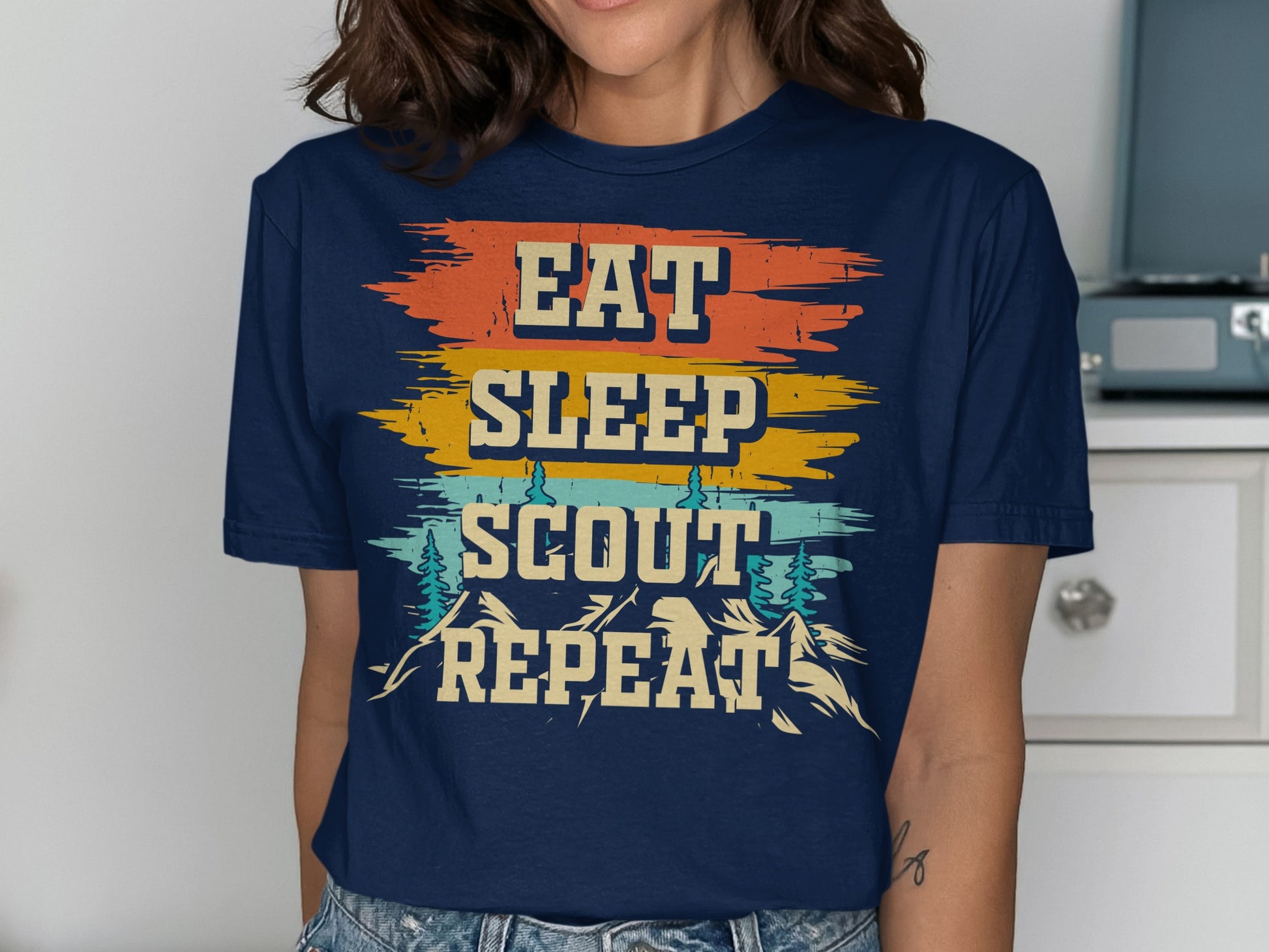 Navy t-shirt with distressed "Eat Sleep Scout Repeat" text and mountain graphics.