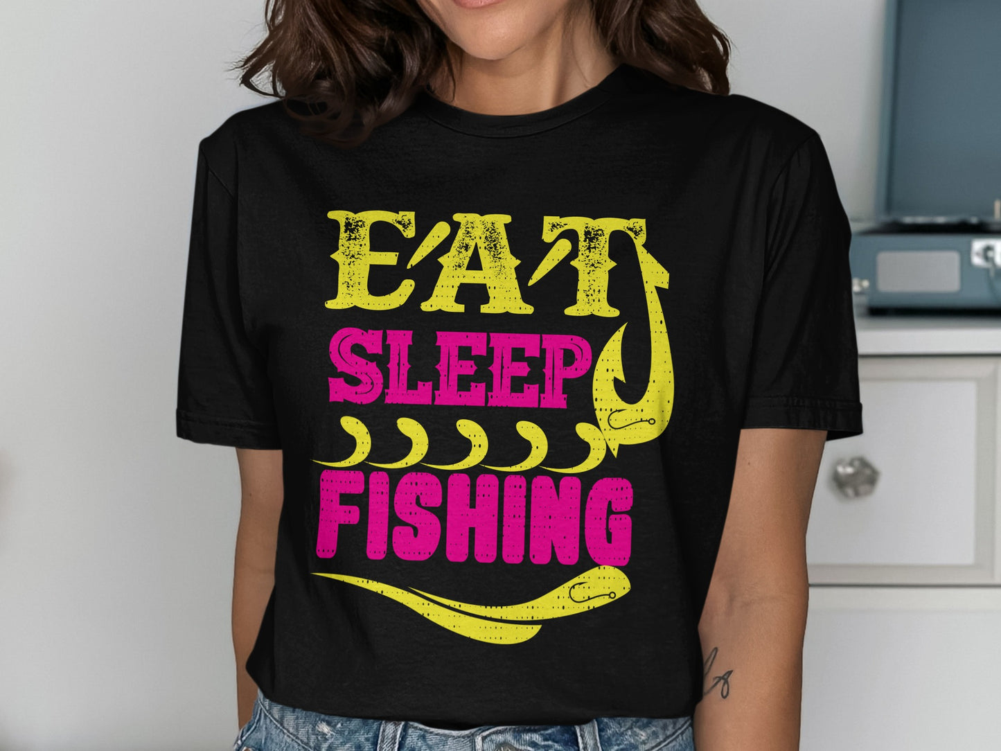 Black t-shirt with yellow and pink "Eat Sleep Fishing" text and fishing hook graphic.