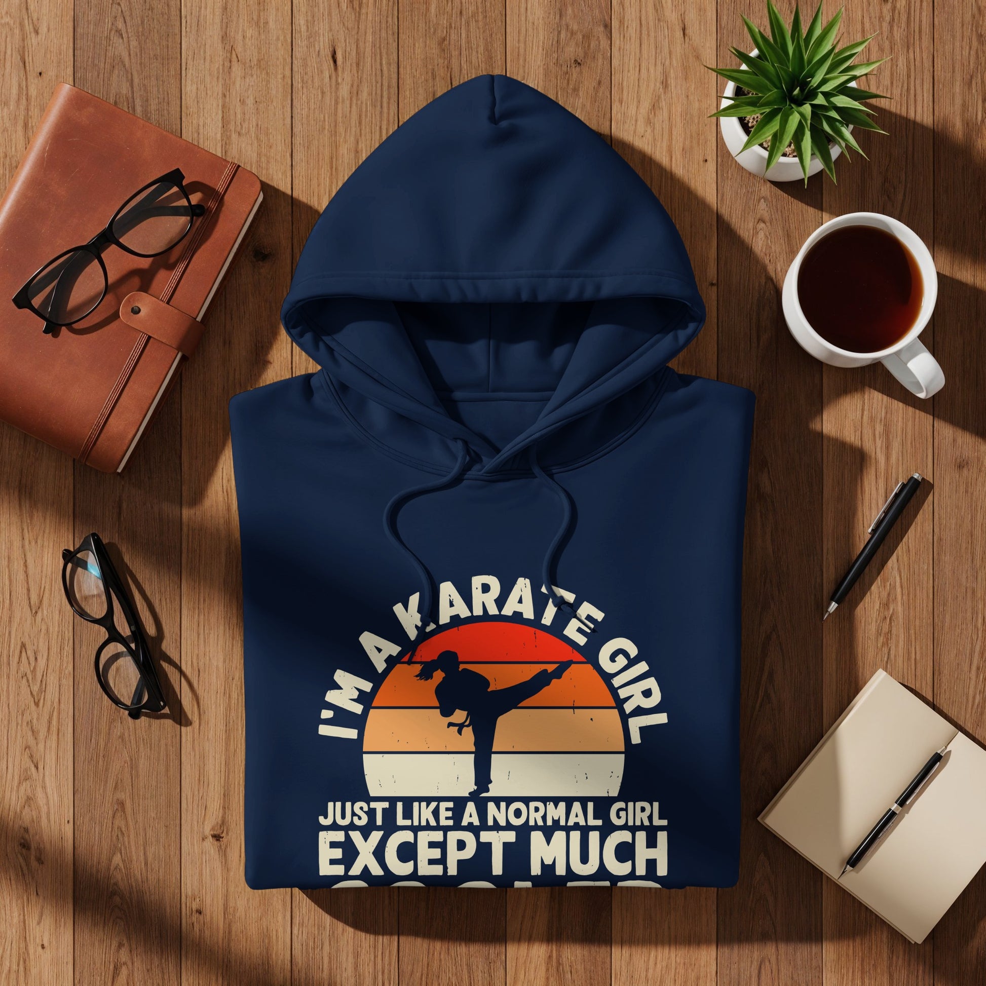 Navy hoodie with "I'm a karate girl, just like a normal girl except much" text and sunset graphic.