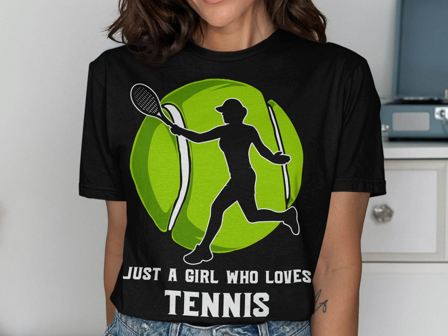 Black t-shirt with white silhouette of a girl playing tennis and large green tennis ball.