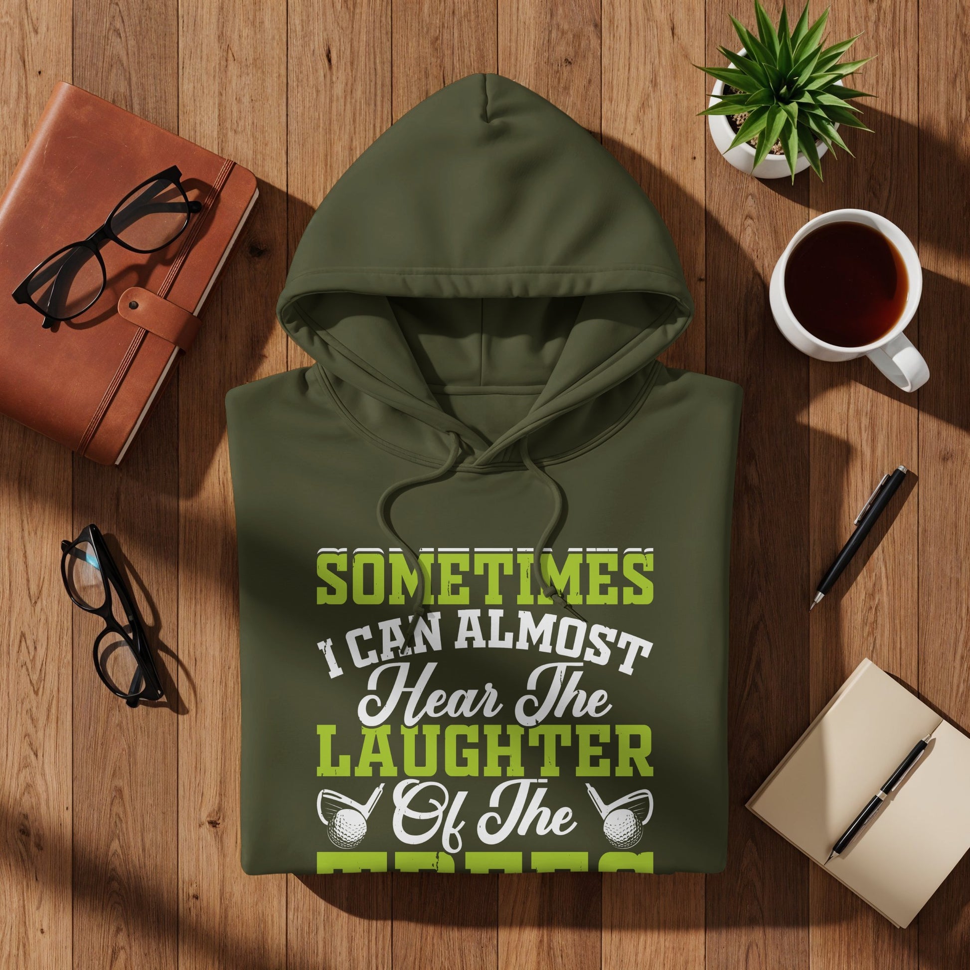 Green hooded sweatshirt with "Sometimes I can almost hear the laughter of the..." text.