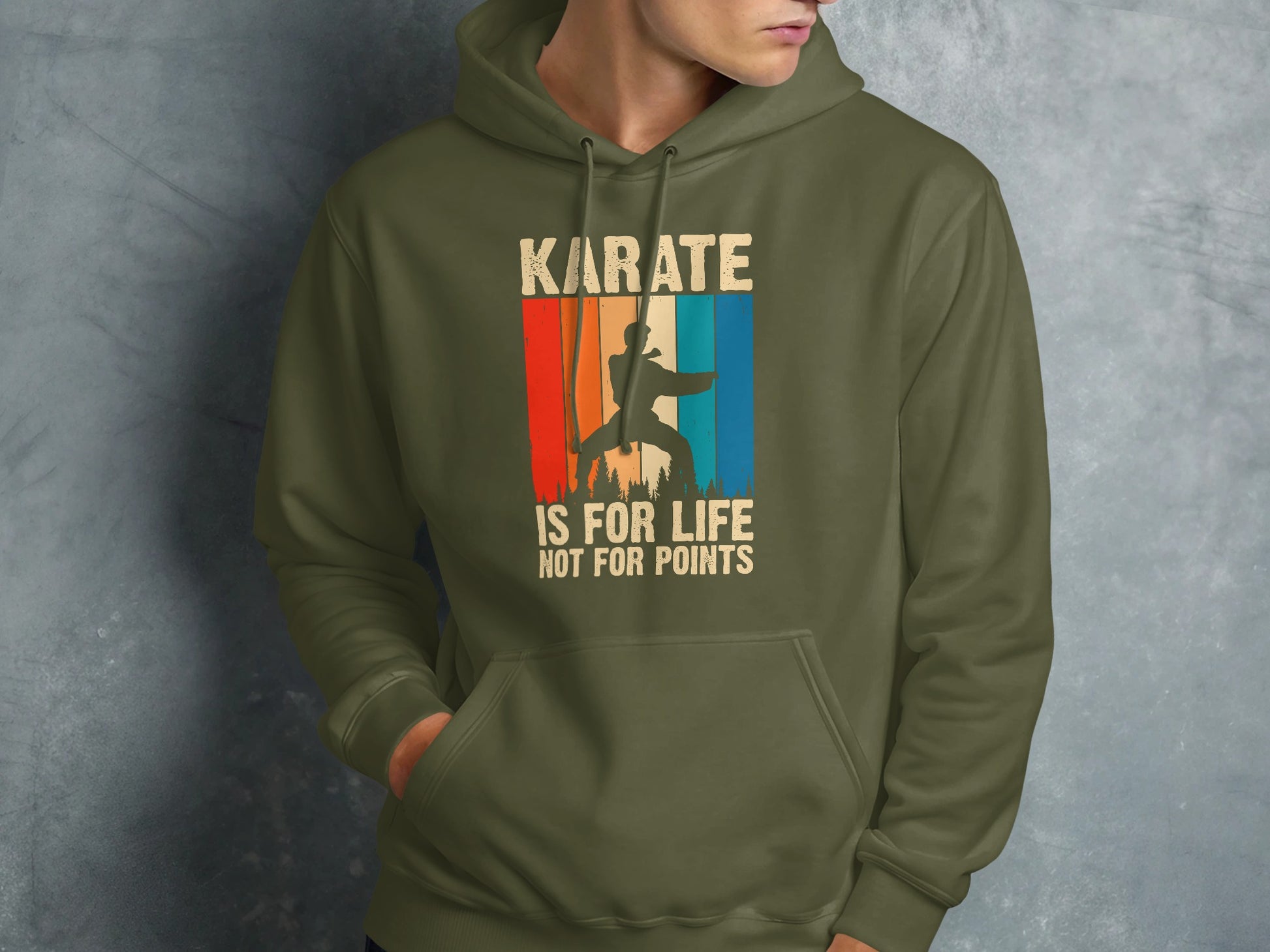 Olive green hoodie with "Karate is for life, not for points" text and sunset graphic.