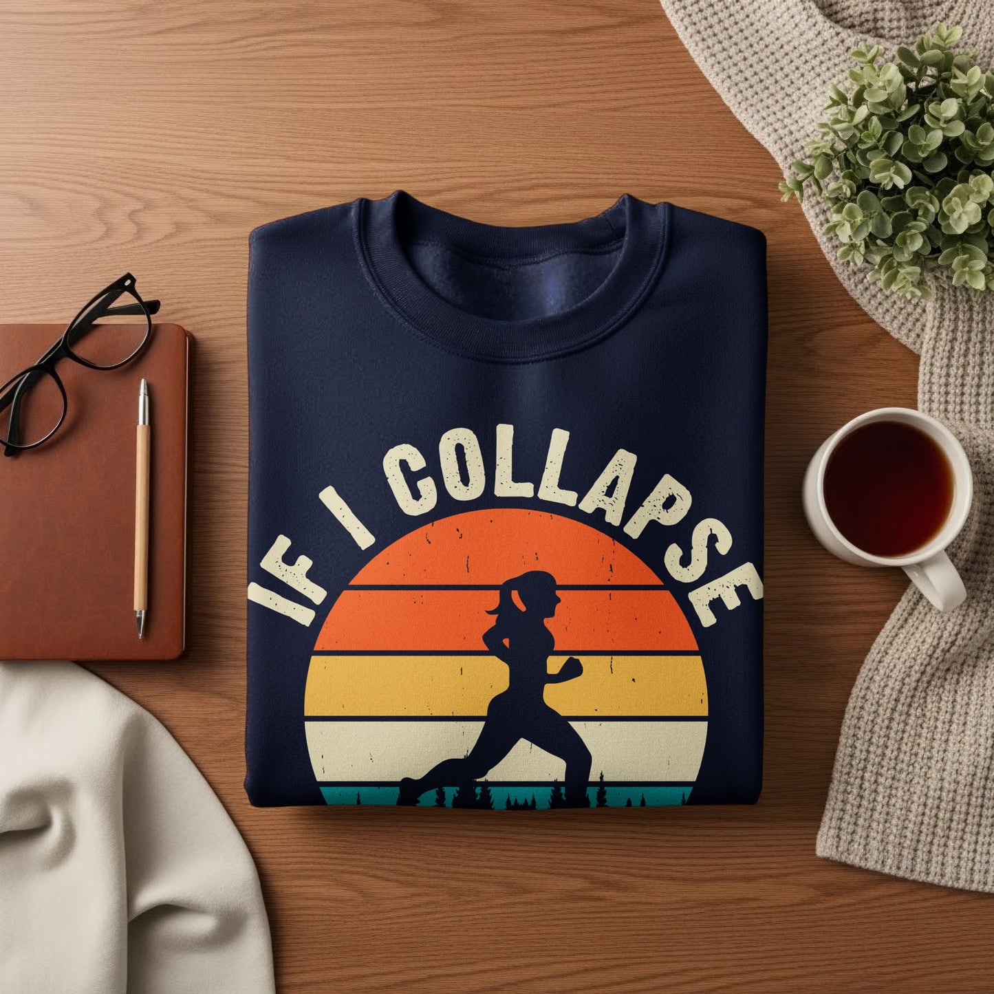 Sweatshirt with runner silhouette and "IF I COLLAPSE" text on sunset background.