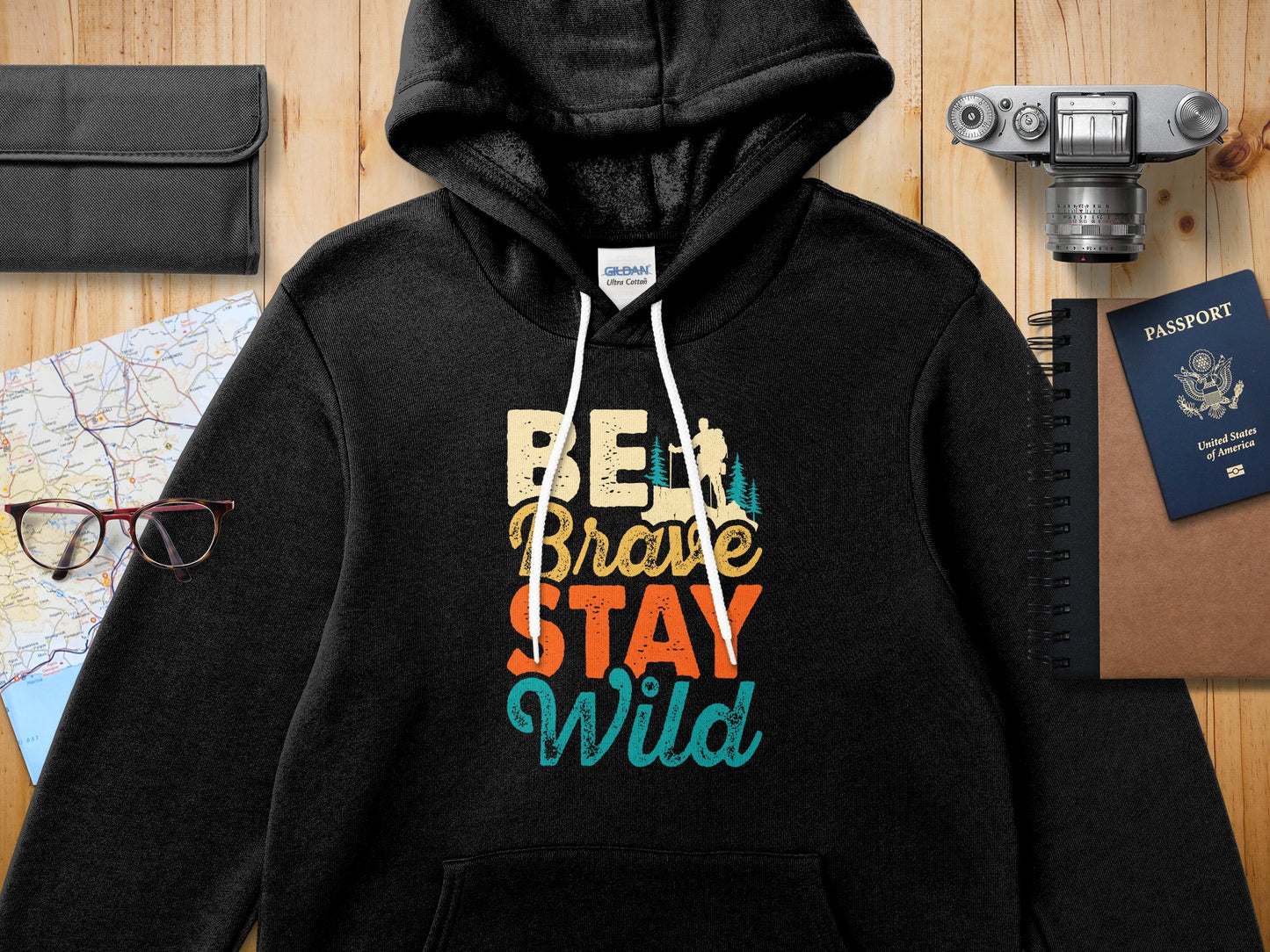 Black Gildan Ultra Cotton hoodie with "BE BRAVE STAY WILD" text.