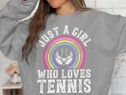 Grey sweatshirt with "JUST A GIRL WHO LOVES TENNIS" and tennis rackets within a rainbow.
