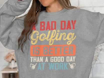 Grey sweatshirt with "A bad day golfing is better than a good day at work" text.