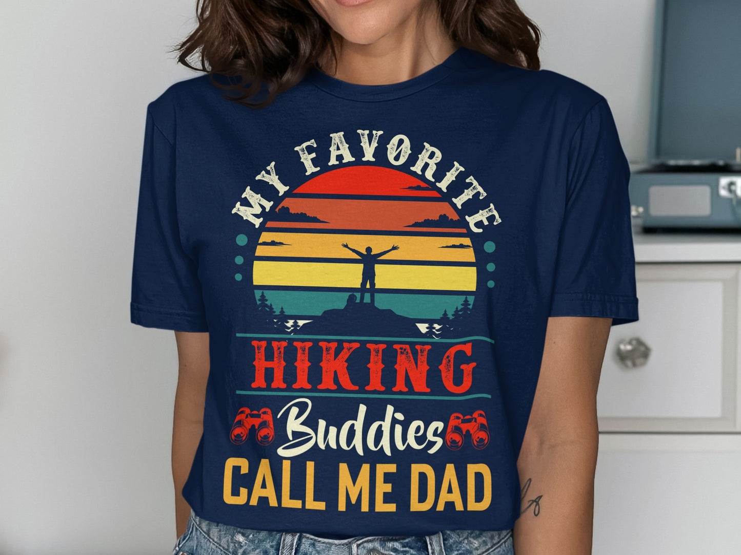 Navy t-shirt with "My Favorite Hiking Buddies Call Me Dad" slogan and sunset mountain graphic.