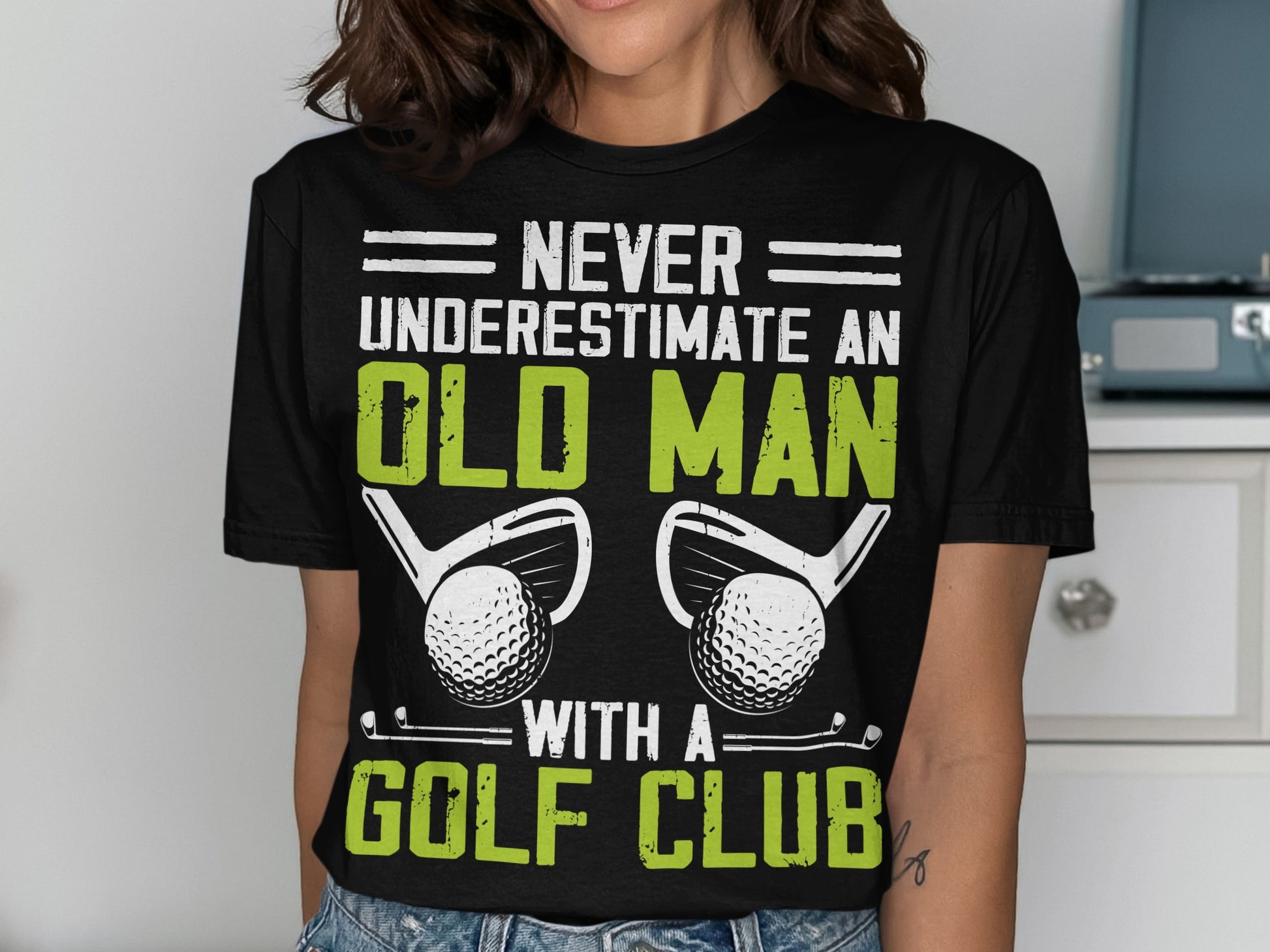 Black t-shirt with text "Never underestimate an old man with a golf club" and golf imagery.