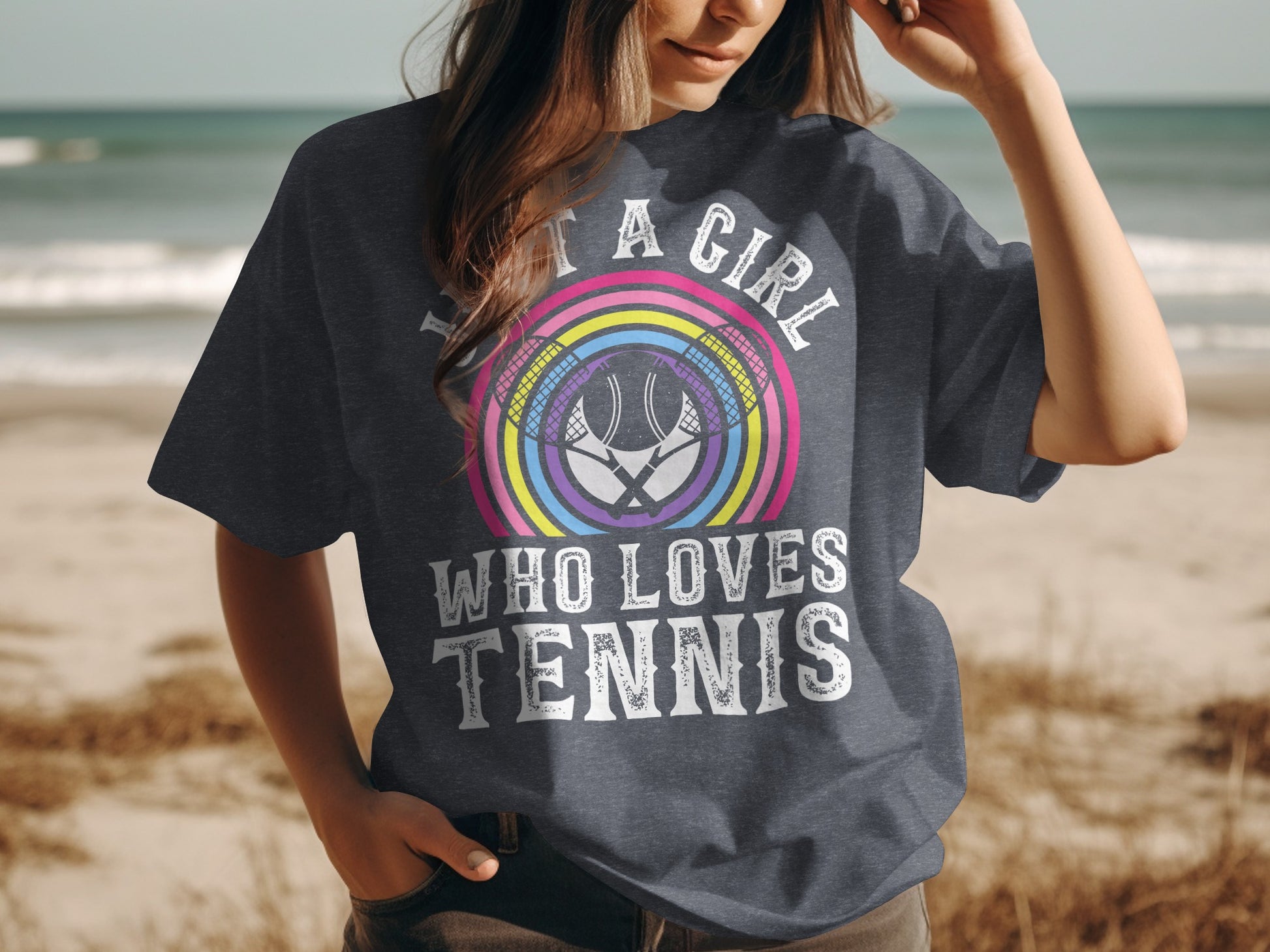Dark gray t-shirt with "A Girl Who Loves Tennis" graphic and rainbow tennis rackets.