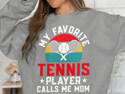 Gray sweatshirt with "My Favorite Tennis Player Calls Me Mom" text and crossed rackets.