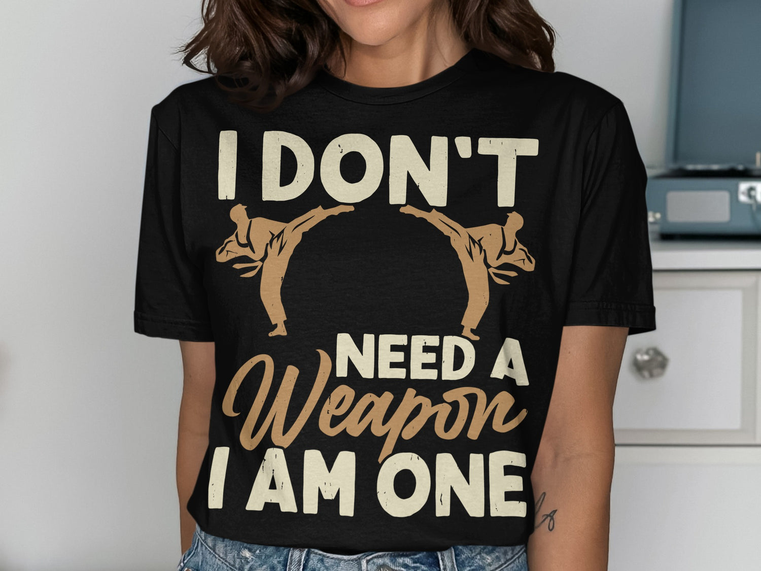 Black t-shirt with "I don't need a weapon I am one" and two taekwondo figures.
