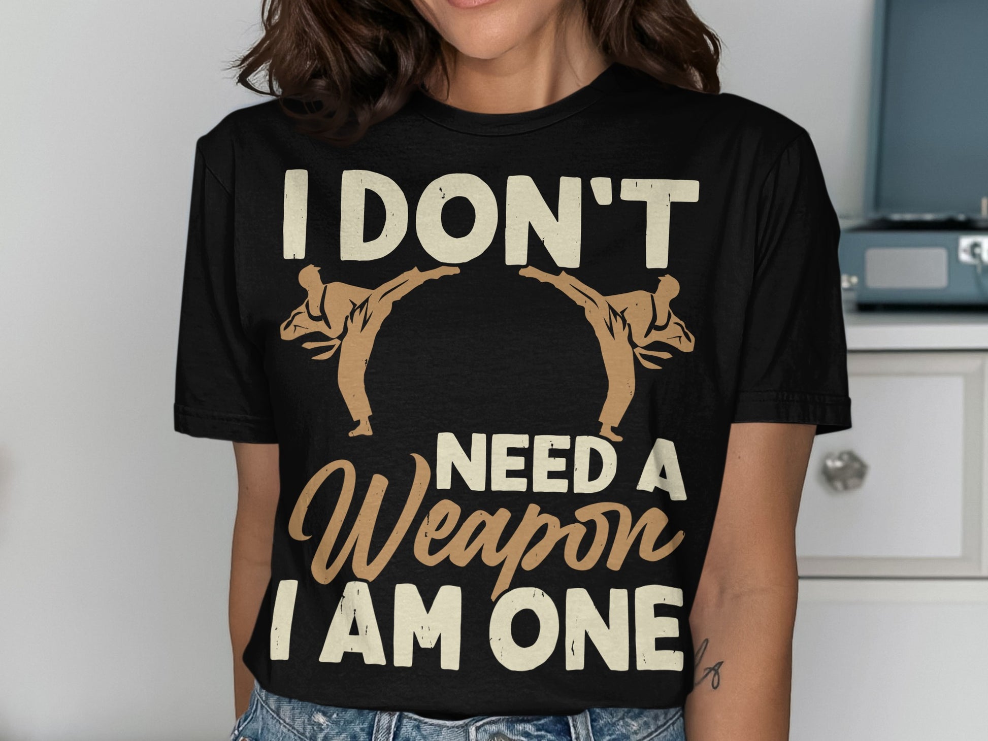 Black t-shirt with "I don't need a weapon I am one" and two taekwondo figures.
