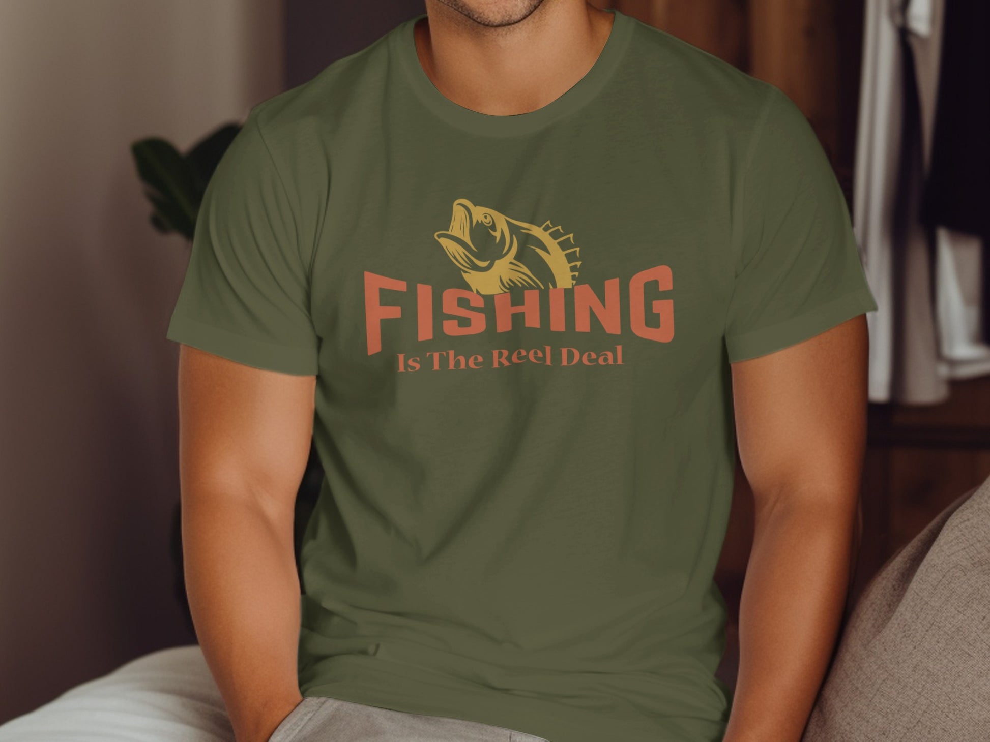 Green t-shirt with orange text "Fishing Is The Reel Deal" and fish graphic.