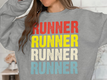 Gray sweatshirt with "RUNNER" printed in red, yellow, cream, and blue.