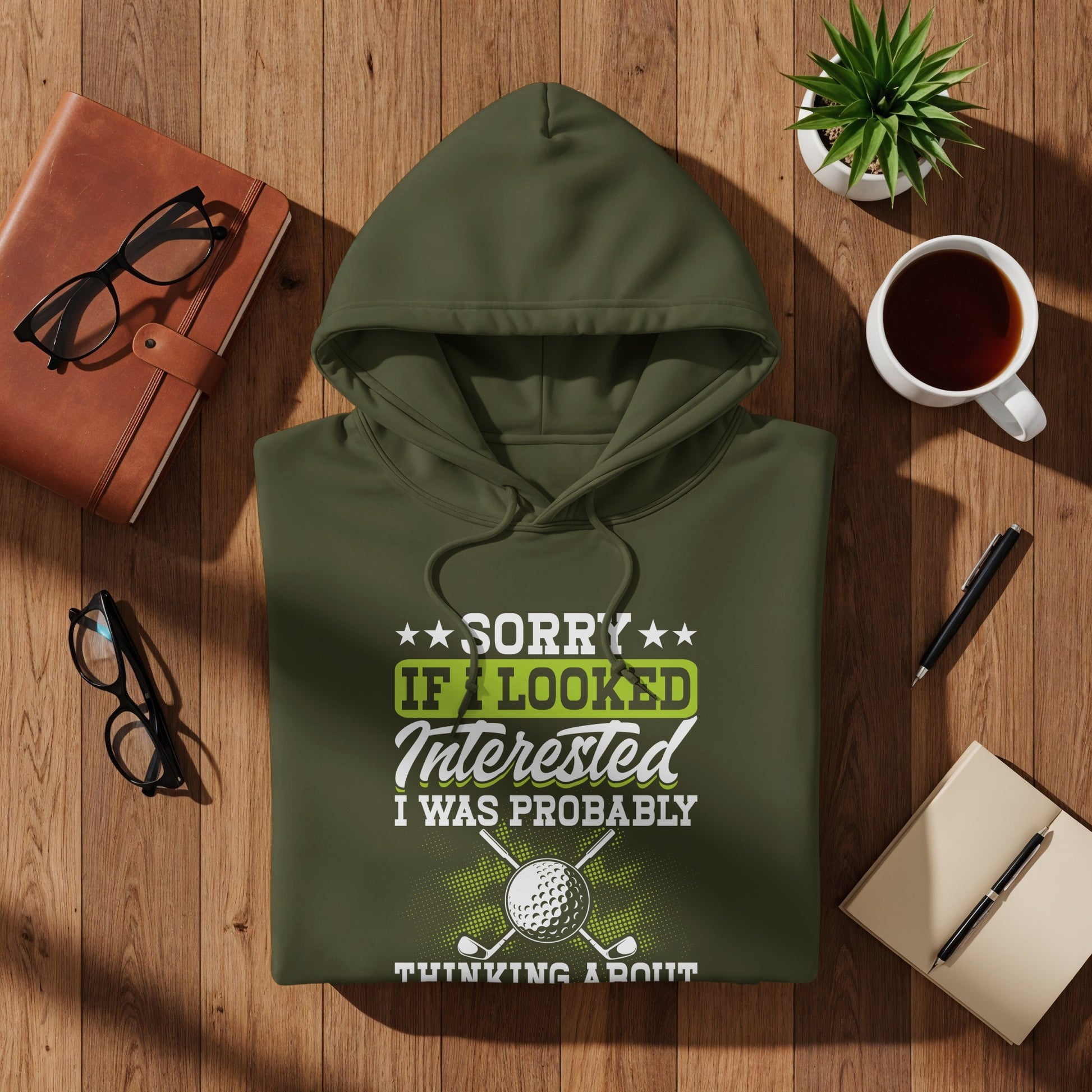 Green hoodie with "Sorry if I looked interested, I was probably thinking about golf" text and golf graphics.