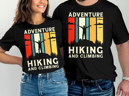 Two people wear matching black t-shirts with a vintage-style mountain adventure graphic.