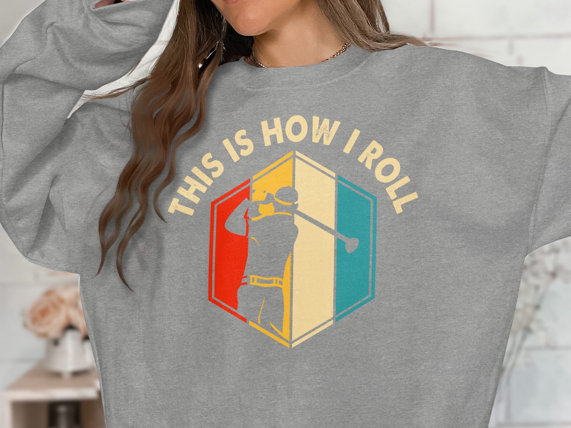 Gray sweatshirt with "THIS IS HOW I ROLL" text and colorful golfer graphic.