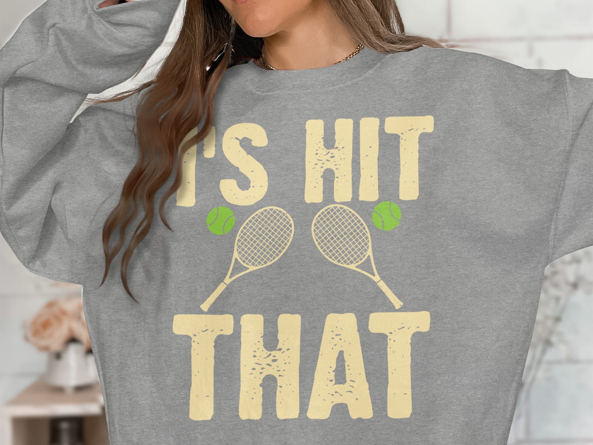 Grey sweatshirt with "IT'S HIT THAT" and tennis rackets and balls graphic.