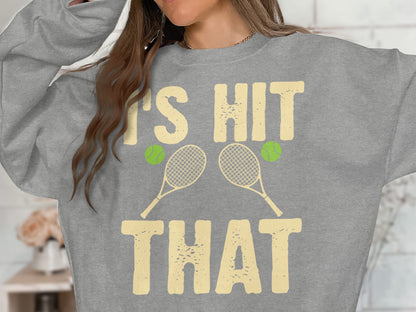 Grey sweatshirt with "IT'S HIT THAT" and tennis rackets and balls graphic.