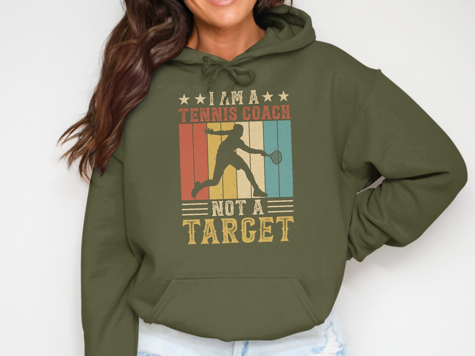 Hoodie with "I Am A Tennis Coach Not A Target" text and retro graphic.
