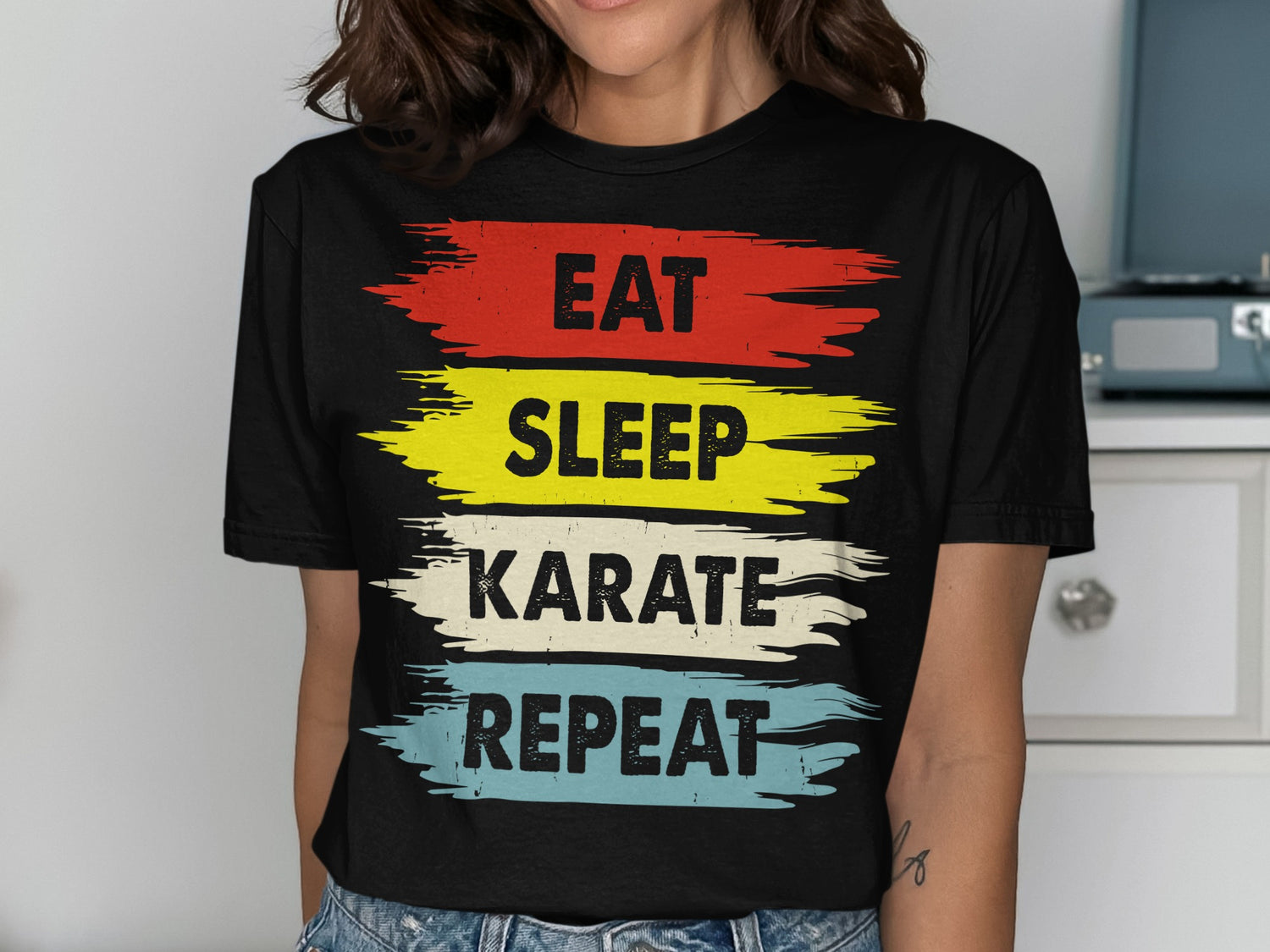 Black t-shirt with "Eat Sleep Karate Repeat" in red, yellow, blue, and white.