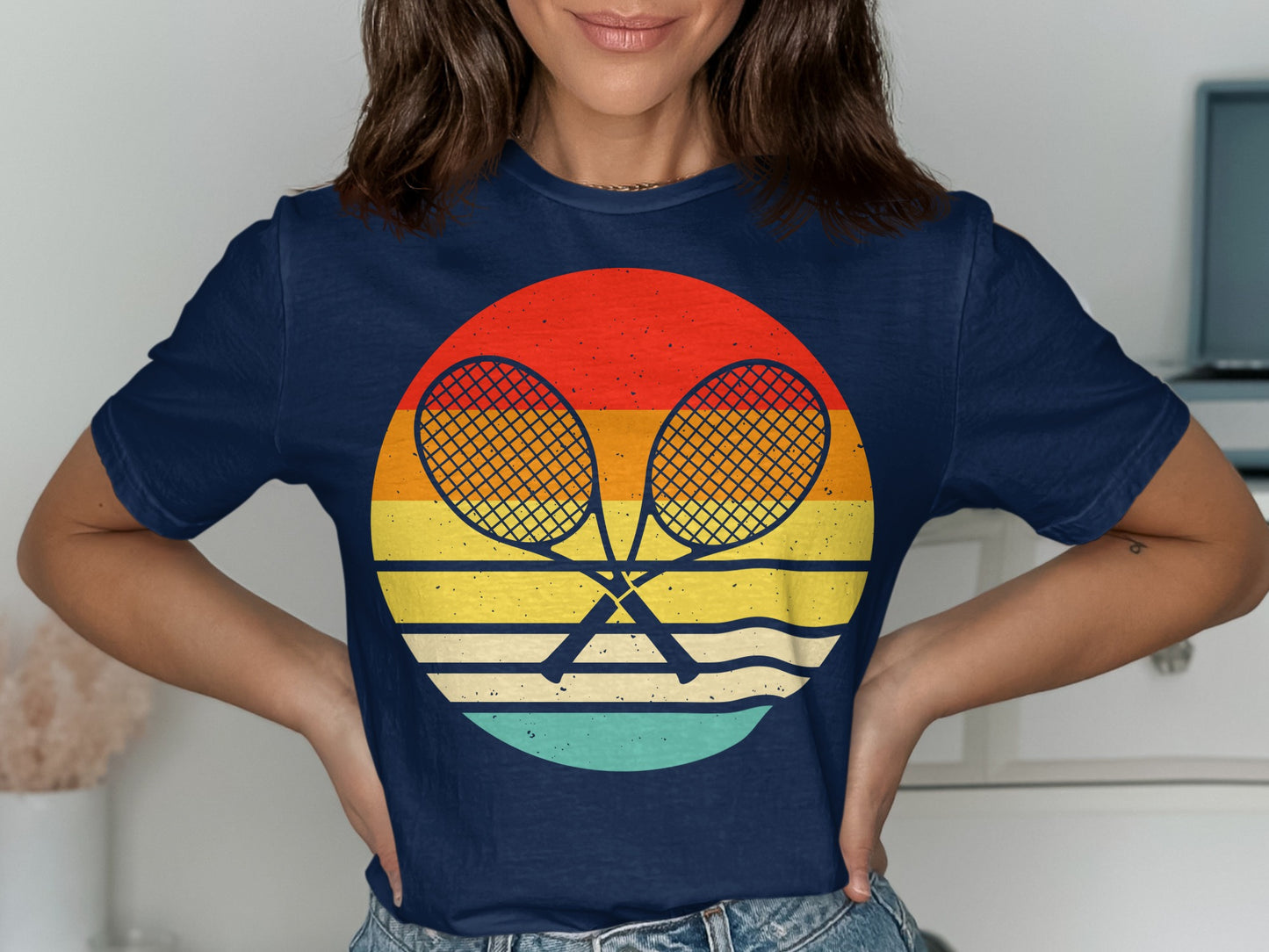 Navy t-shirt with crossed tennis rackets inside a retro sunset circle.