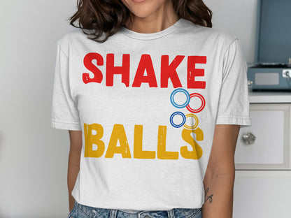 White t-shirt with red text "SHAKE" and yellow text "BALLS".