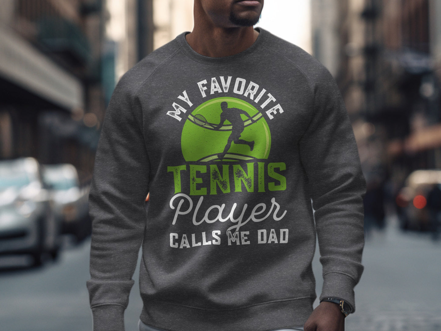 Men's gray sweatshirt with green tennis graphic and "My Favorite Tennis Player Calls Me Dad" text.