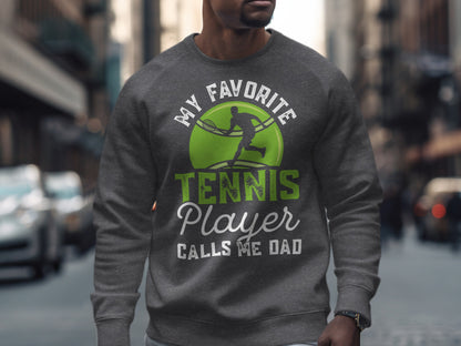 Men's gray sweatshirt with green tennis graphic and "My Favorite Tennis Player Calls Me Dad" text.