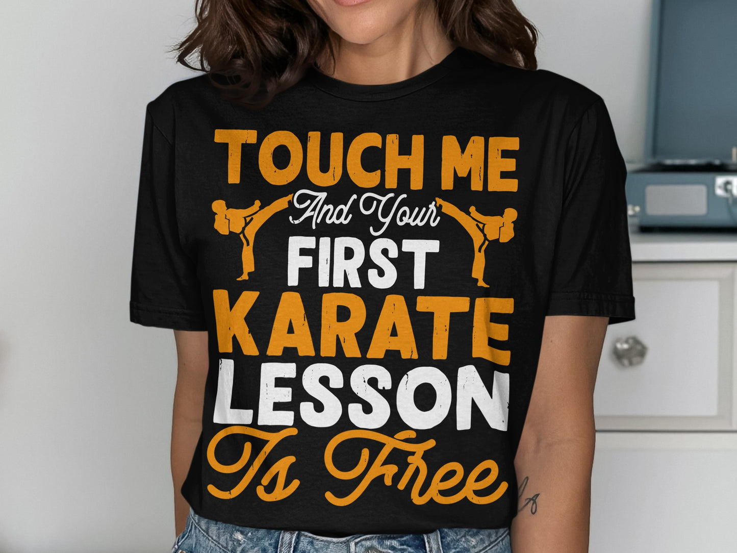 Black t-shirt with orange and white text "Touch me and your first karate lesson is free".