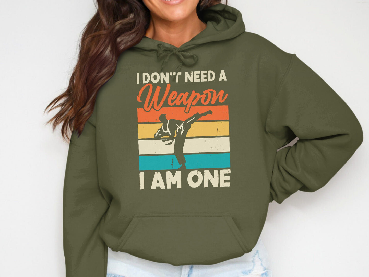Green hoodie with graphic of a martial artist and text "I Don't Need a Weapon I Am One".
