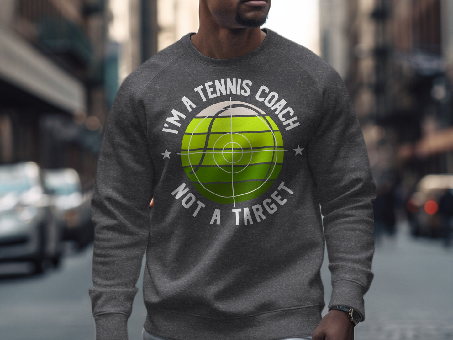 Gray sweatshirt with text "I'm a tennis coach not a target" and green tennis ball graphic.