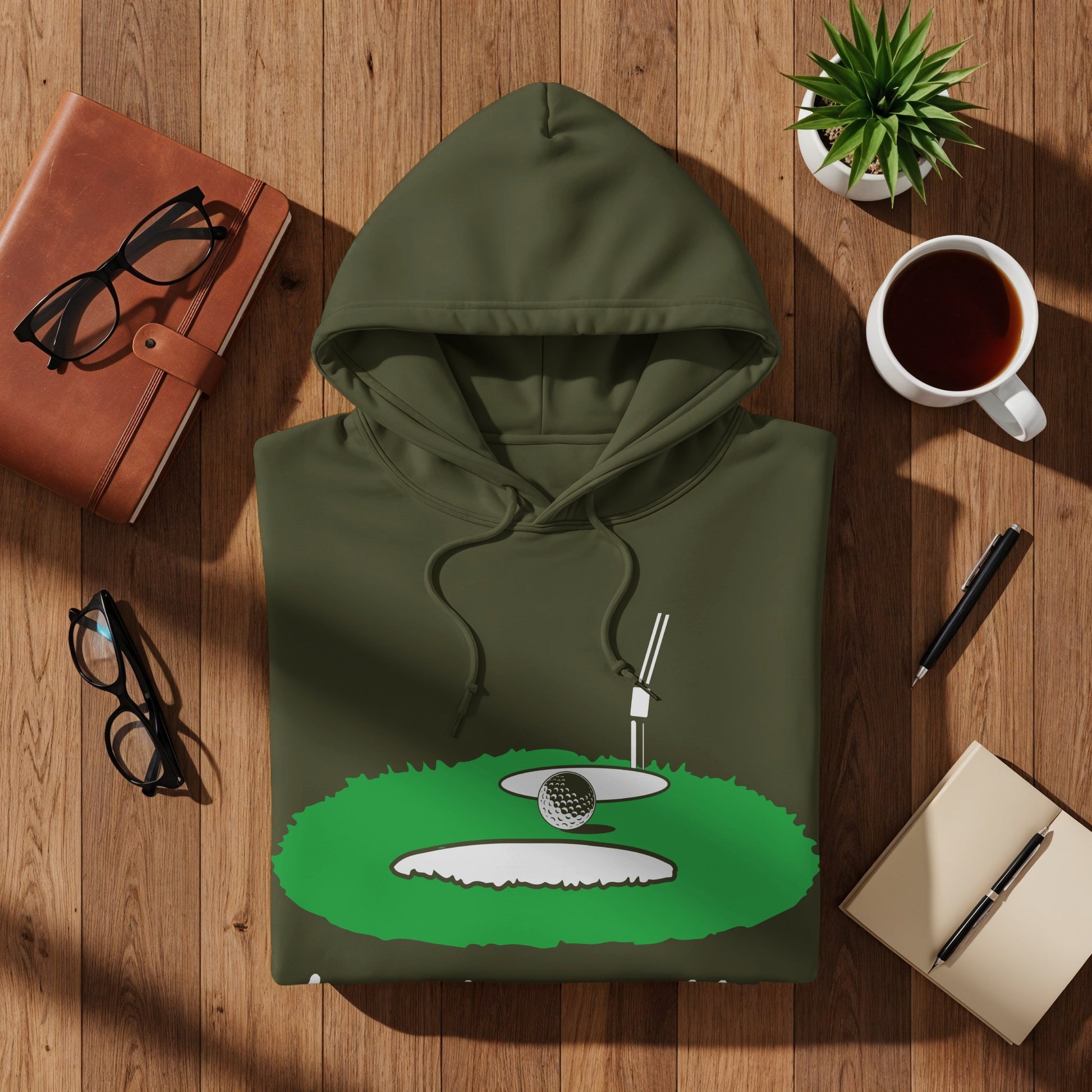 Green hoodie with golf course graphic featuring a ball, tee, and sand trap.