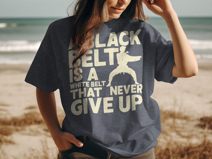 T-shirt with "Black belt is a white belt that never give up" and martial artist silhouette.