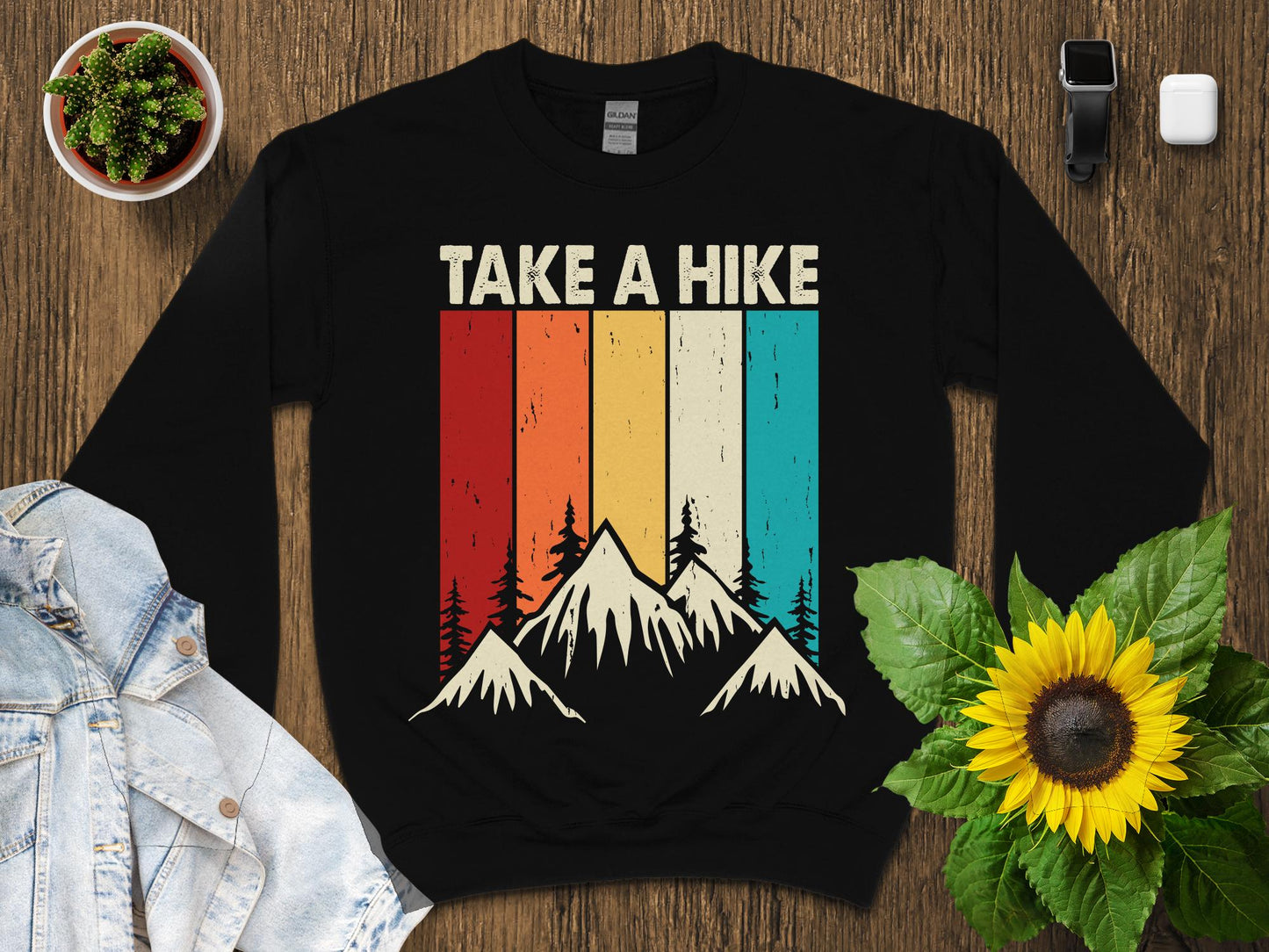 Black sweatshirt with "TAKE A HIKE" text over a mountain sunset graphic.