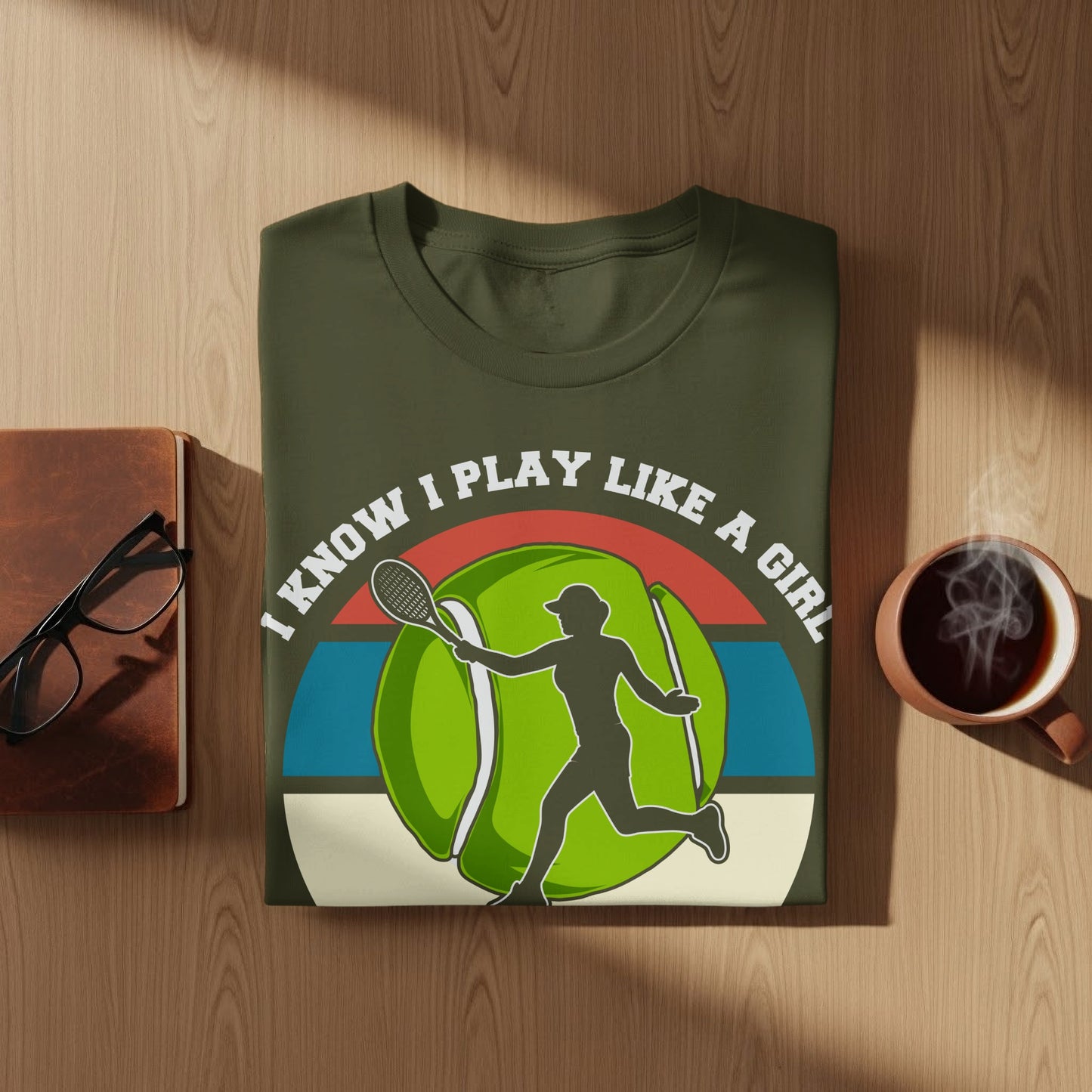 Olive green t-shirt with graphic of tennis player and text "I know I play like a girl".