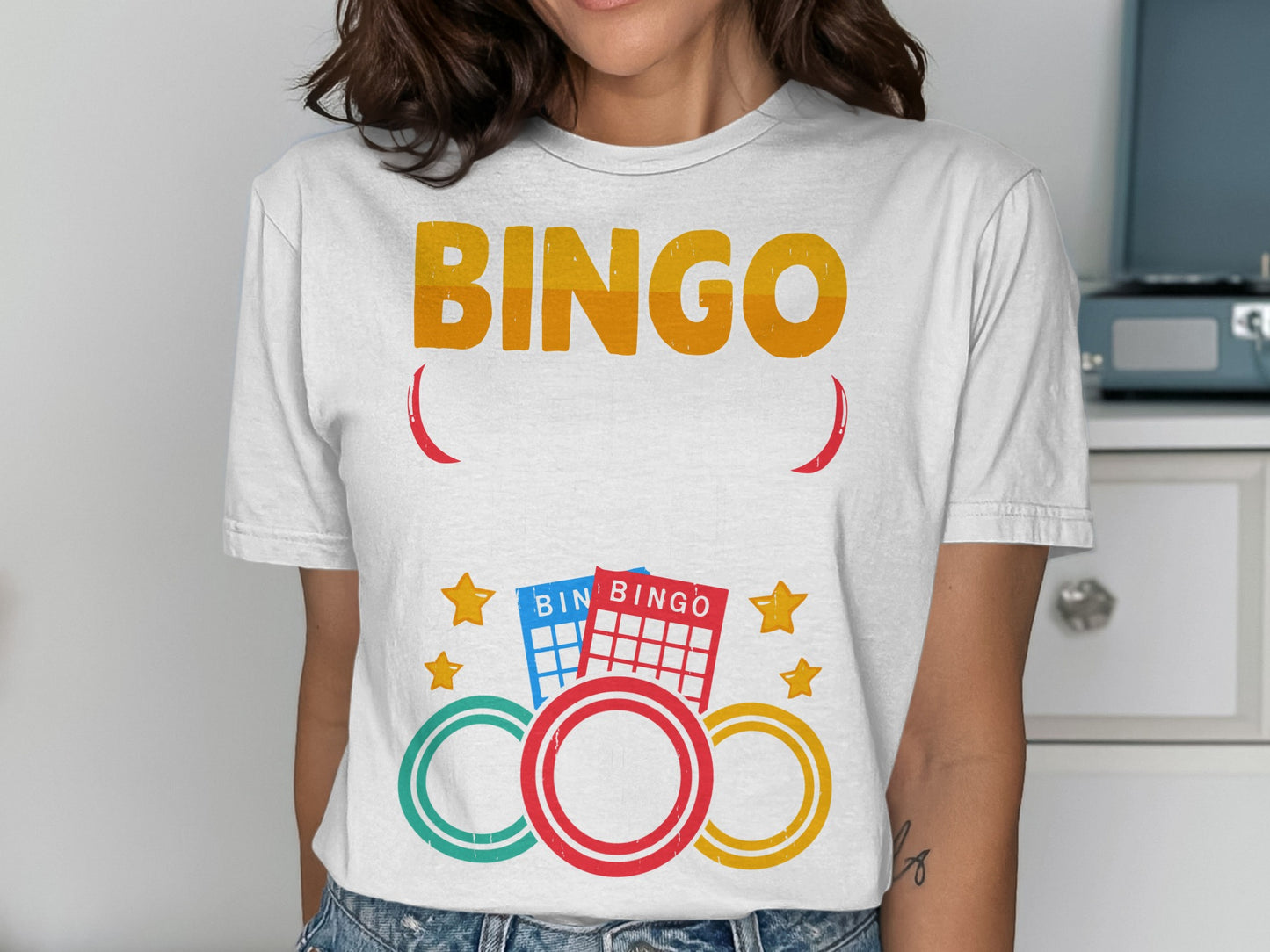 White t-shirt with "BINGO" text and colorful bingo cards and rings.