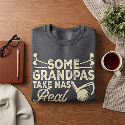 Dark gray sweatshirt with "Some Grandpas Take Naps Real" text and golf graphics.