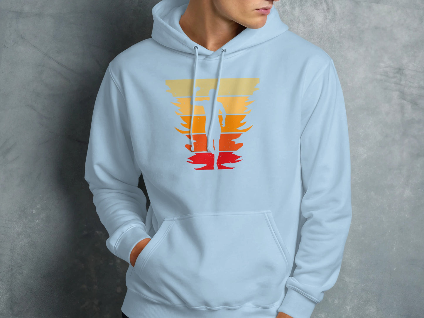 Light blue hoodie with a silhouette of a surfer against a sunset graphic.