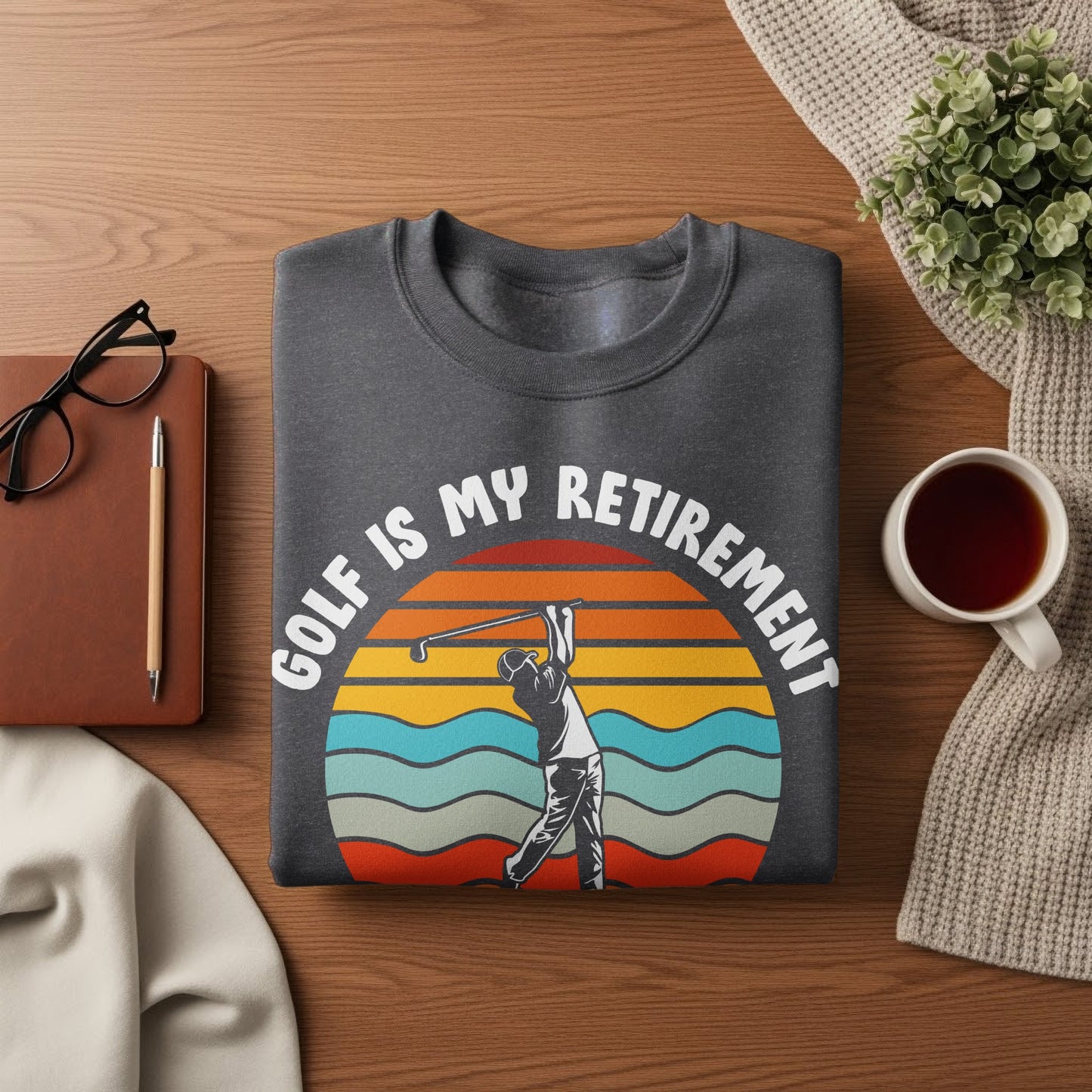 Dark gray sweatshirt with "Golf is My Retirement" text and sunset graphic.