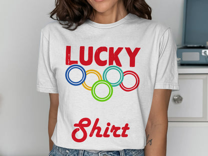 White t-shirt with red "LUCKY" text and Olympic rings above "Shirt".