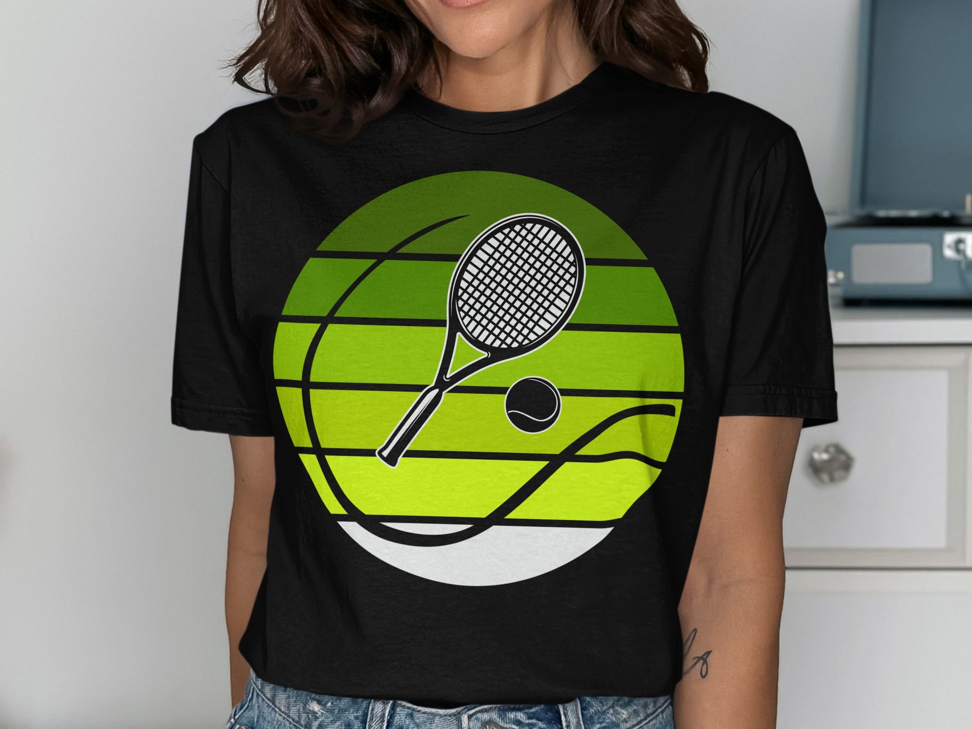 Black t-shirt with a green striped circle featuring a tennis racket and ball.