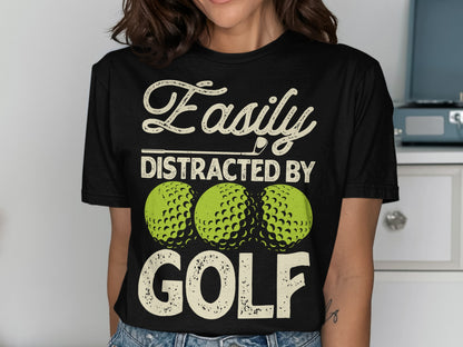 Black t-shirt with "Easily Distracted By Golf" and three golf balls.