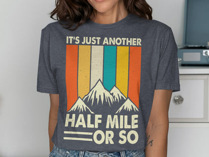 Dark gray t-shirt with mountains and "IT'S JUST ANOTHER HALF MILE OR SO" text.