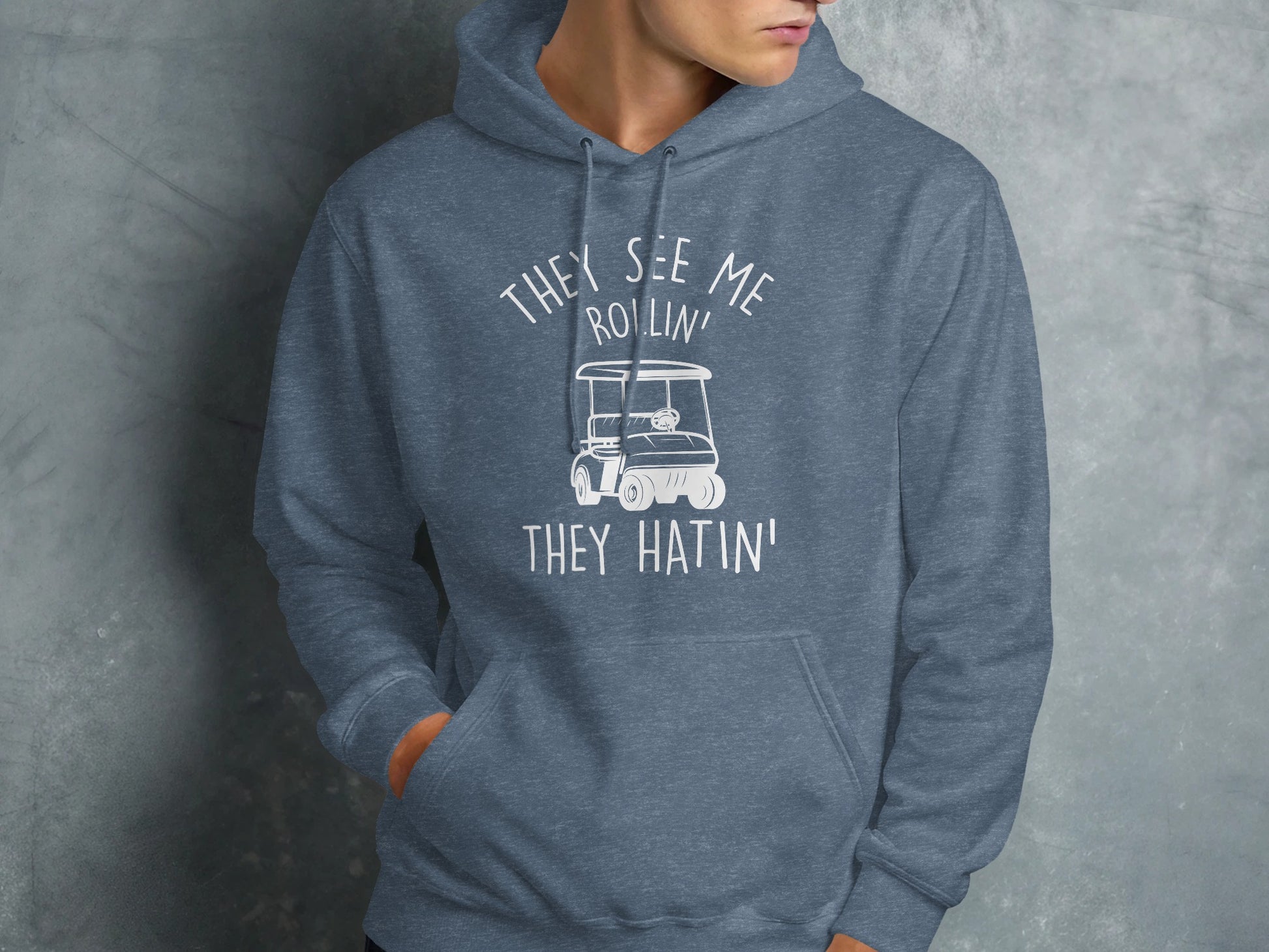 Blue hooded sweatshirt with "They see me rollin' they hatin'" text and golf cart graphic.