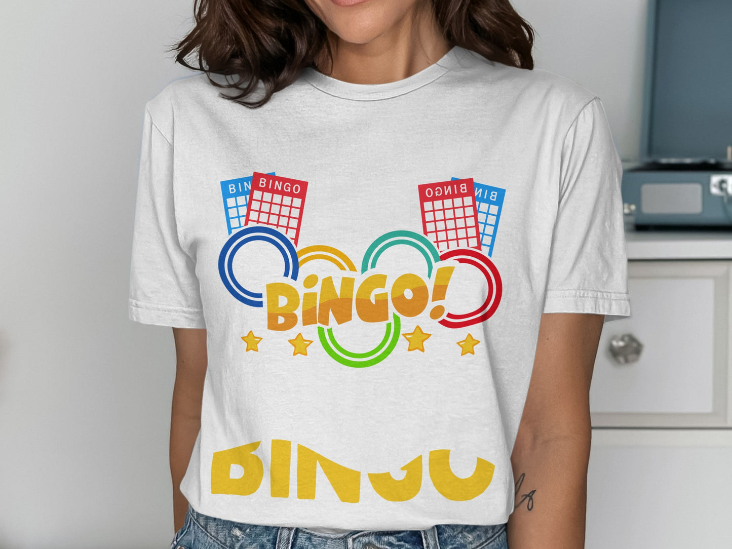 White t-shirt with "Bingo!" text, colorful bingo cards, rings, and stars.