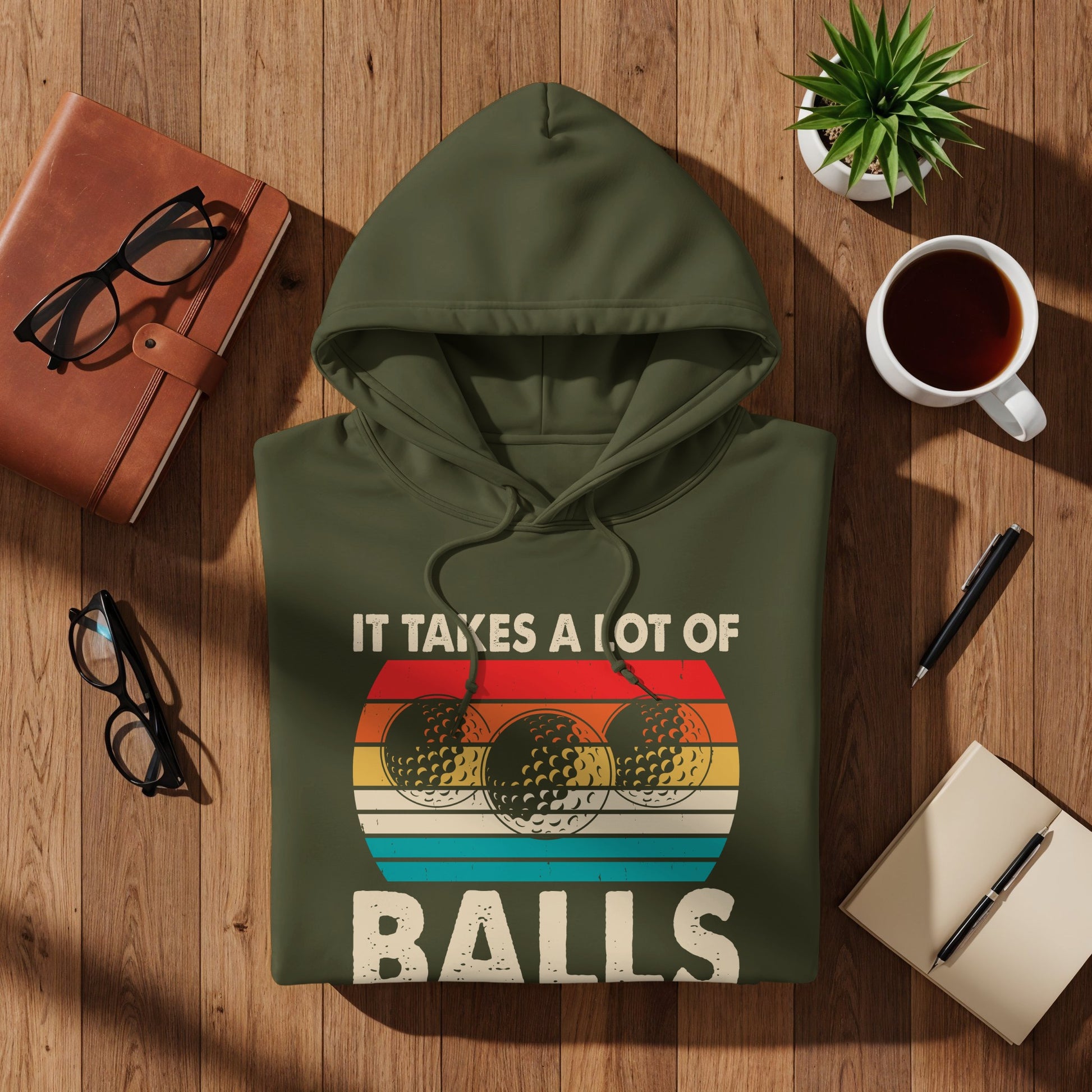 Olive green hoodie with "IT TAKES A LOT OF BALLS" text and three golf balls.
