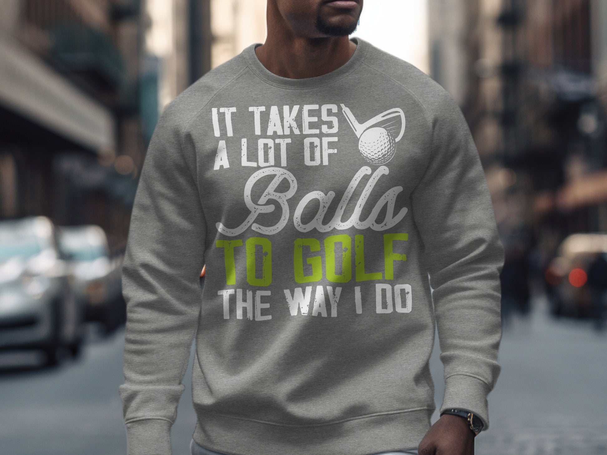 Gray sweatshirt with text "It Takes A Lot Of Balls To Golf The Way I Do" and golf club.