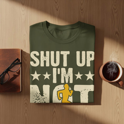 Olive green t-shirt with "SHUT UP I'M NOT" and a running figure graphic.